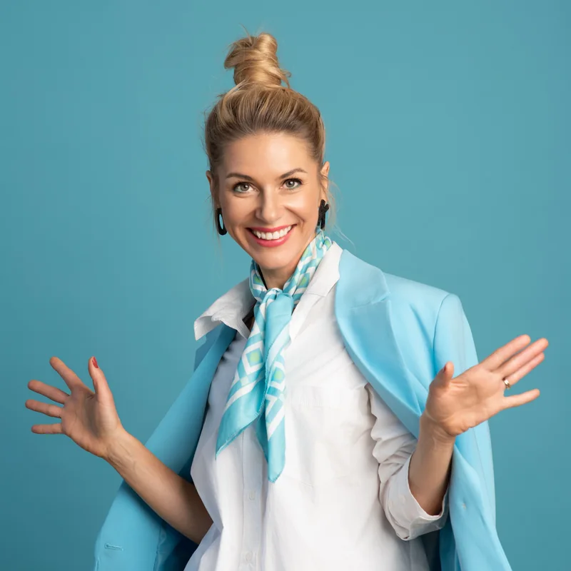 Olga Kairienė šviesiai mėlynu švarku, išskėstomis rankomis